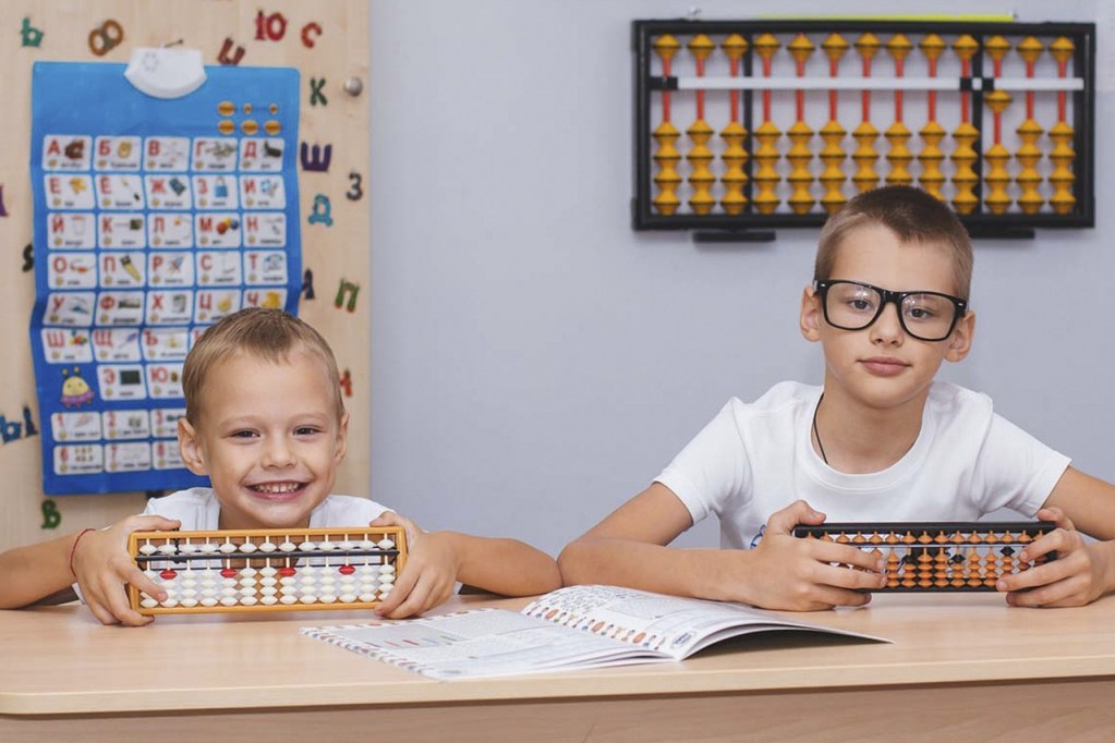 two boys holding abacus preparing to calculate their Budget for their budgeting activities for kids back-to-school edition