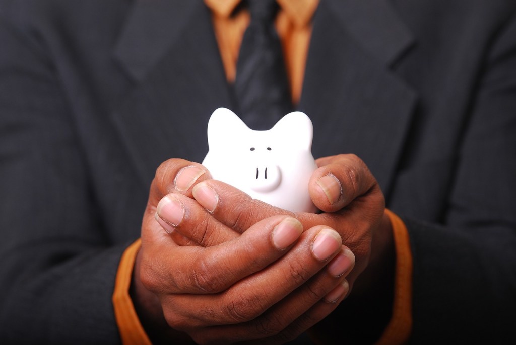 hands holding a piggy bank representing the importance of starting early as the best way to save money for kids