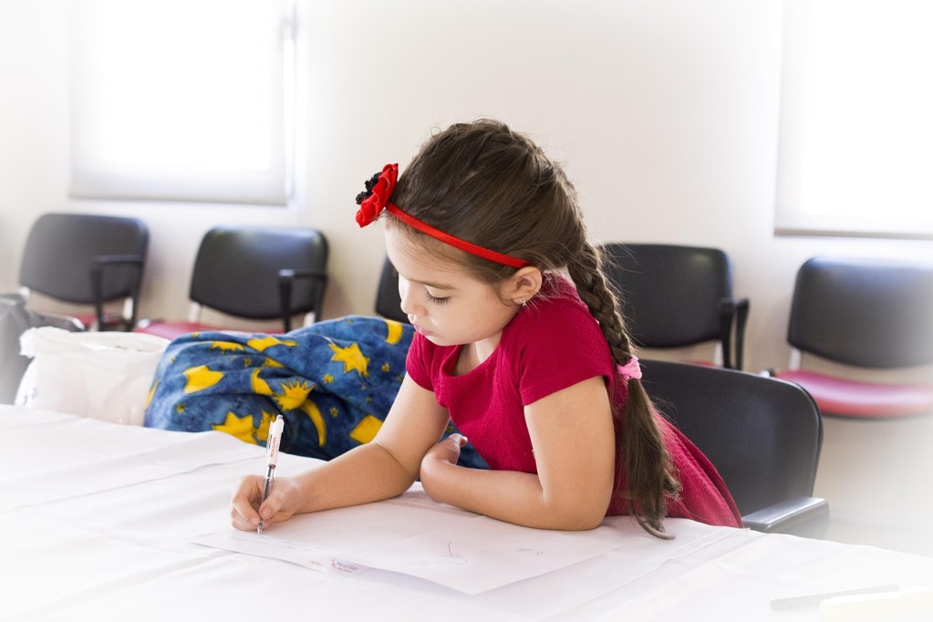 Little girl preparing her back-to-school shopping list as part of budgeting activities for kids