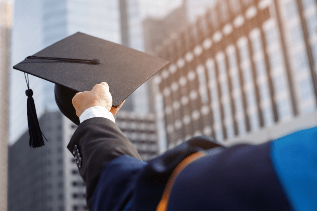 Hand holding a graduation hat representing that there are Strategies for saving and Maximizing Financial Aid to go to college